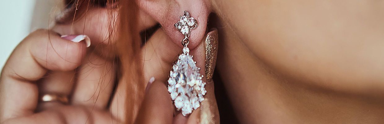 close up of girl's ear with a infinity loop diamond dangle earring